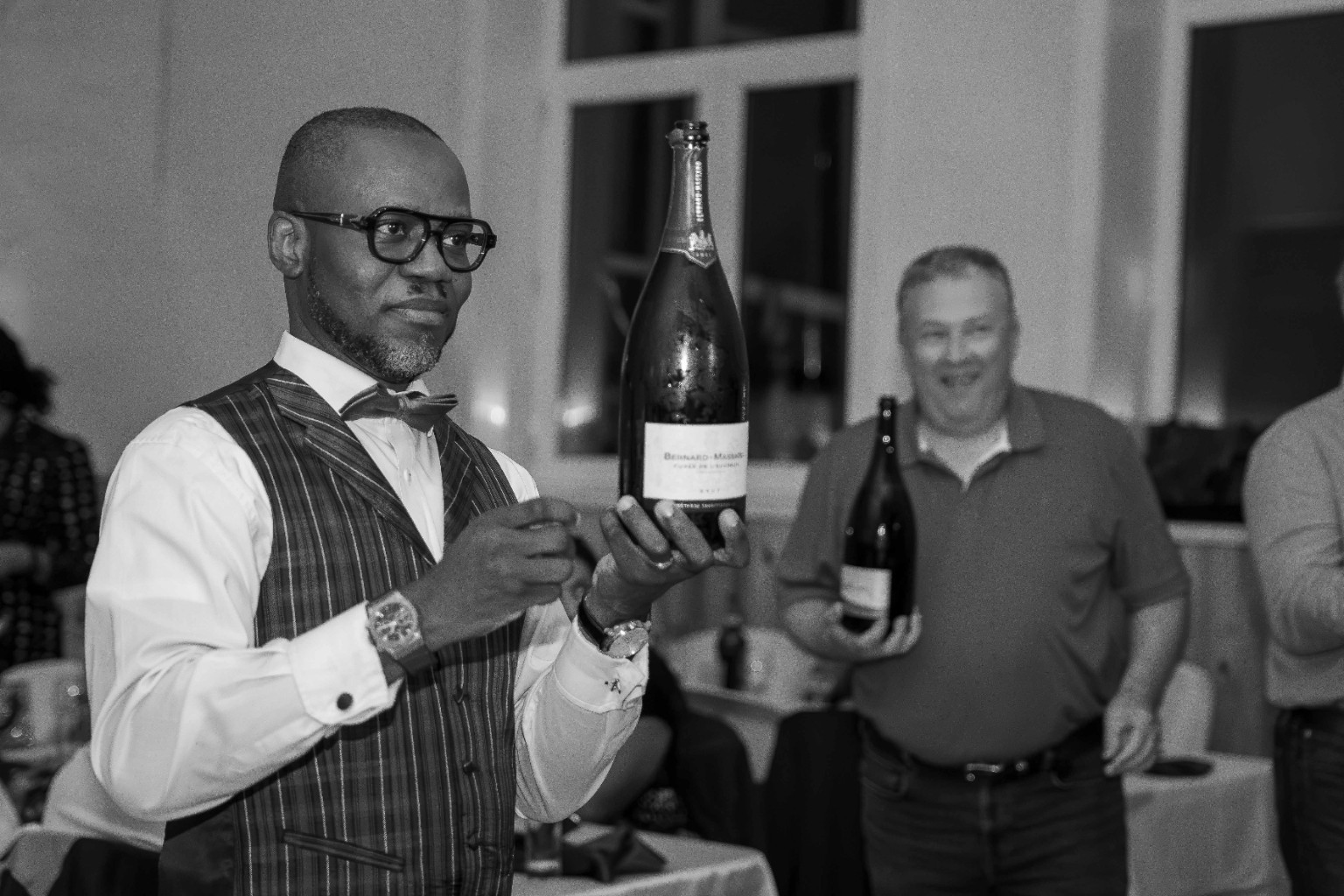 Un invité sert du vin pendant une réception, en noir et blanc