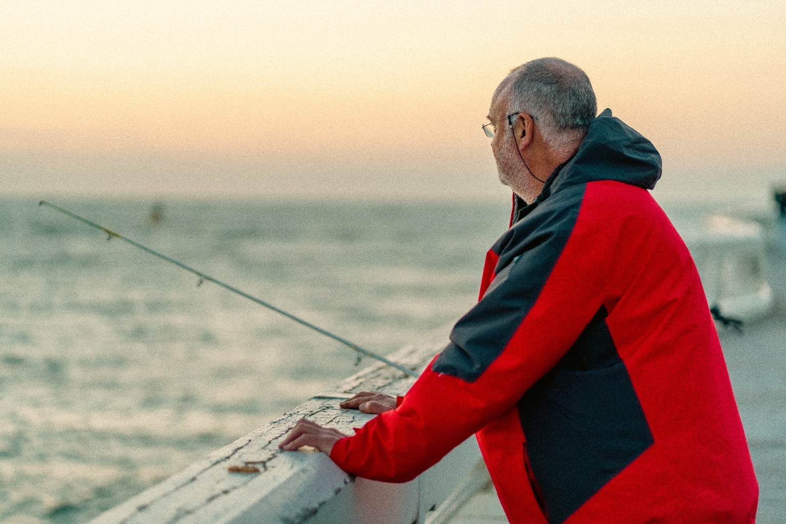 Un pêcheur au bord de la mer au coucher du soleil