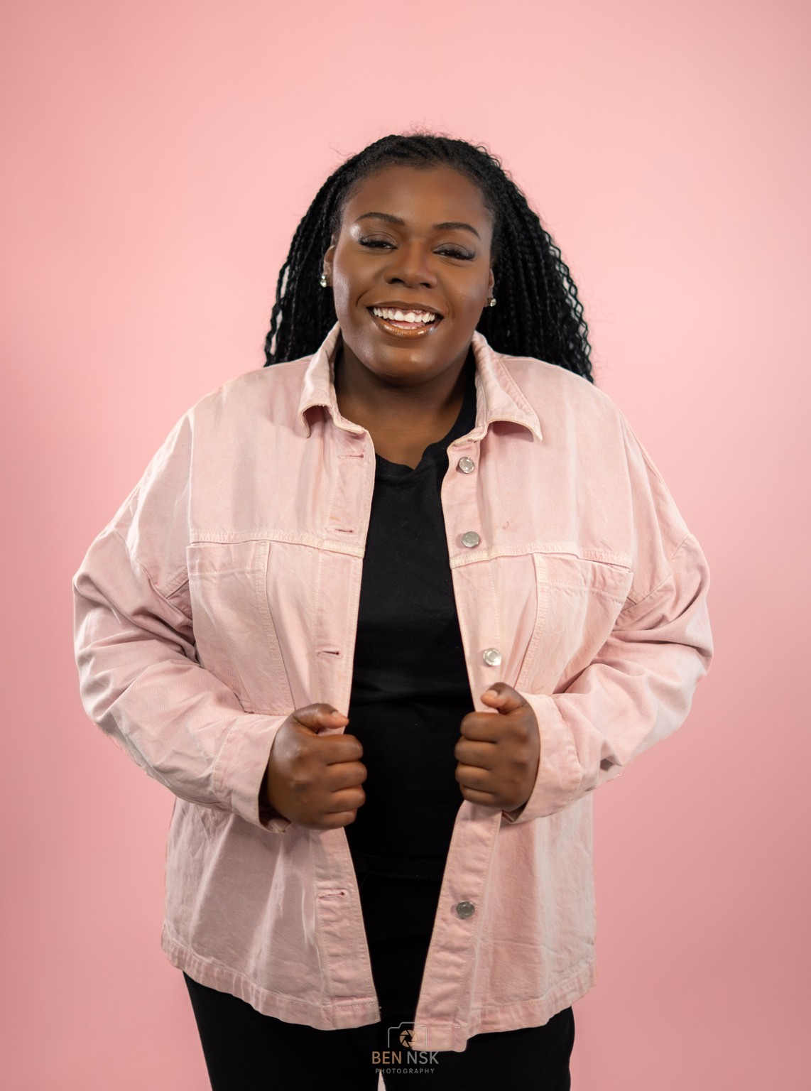 Portrait en studio d’une femme en veste rose sur fond rose